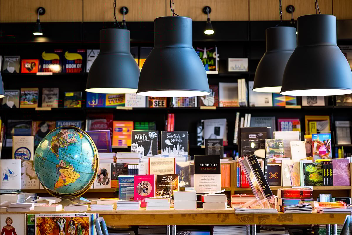 Inside a bookshop with black metal electric lamps hanging - Shutterstock