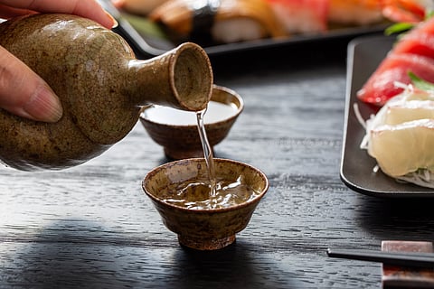 Sake being poured out a tumbler