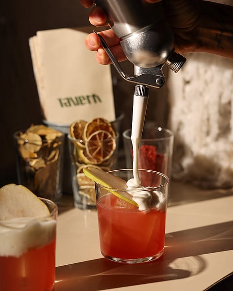 The Poşe Pera cocktail has Irish whiskey, lillet, red wine, poached pears, and lemonade cream