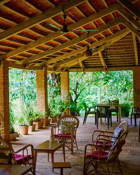 The bungalow features a red-tiled roof and a beautiful veranda