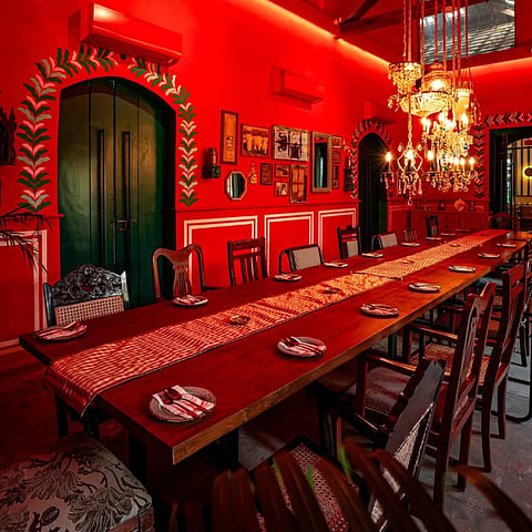 The ambience reflects the heritage of Tamil Nadu with intricate wooden furnishings, traditional brass lamps, and vibrant murals