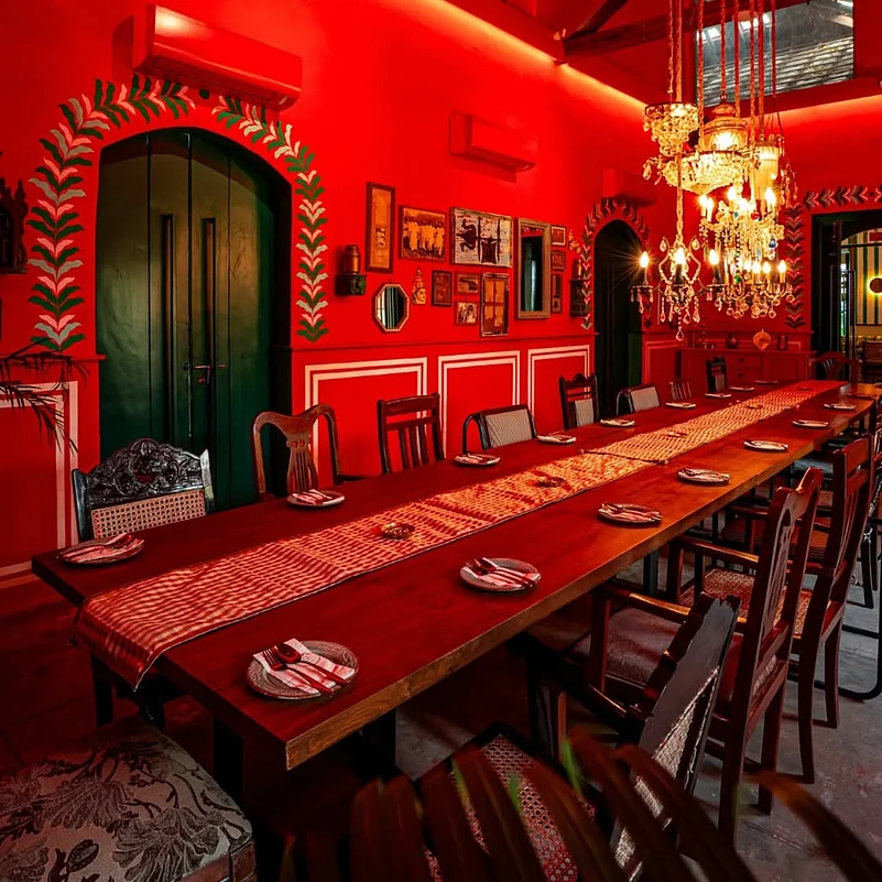 The ambience reflects the heritage of Tamil Nadu with intricate wooden furnishings, traditional brass lamps, and vibrant murals