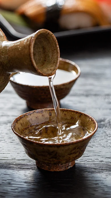 Shutterstock : Sake being poured out a tumbler