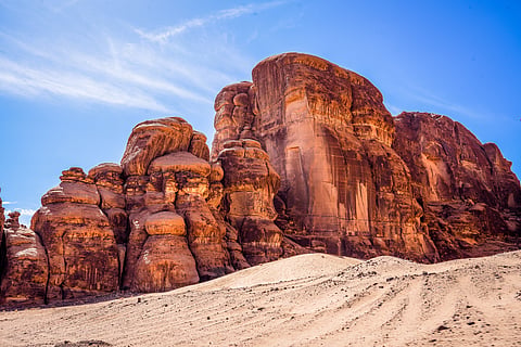 Striking rock formations in the desert of AlUla showcase dramatic, weathered shapes against a backdrop of golden sands