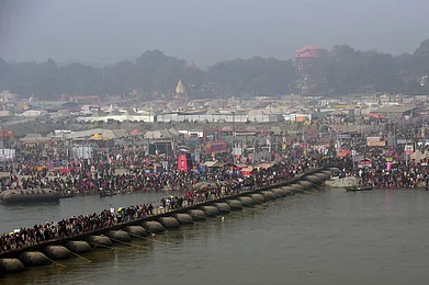 prabhat kumar verma/Shutterstock : People wait to take a dip in the Triveni Sangam of Prayagraj