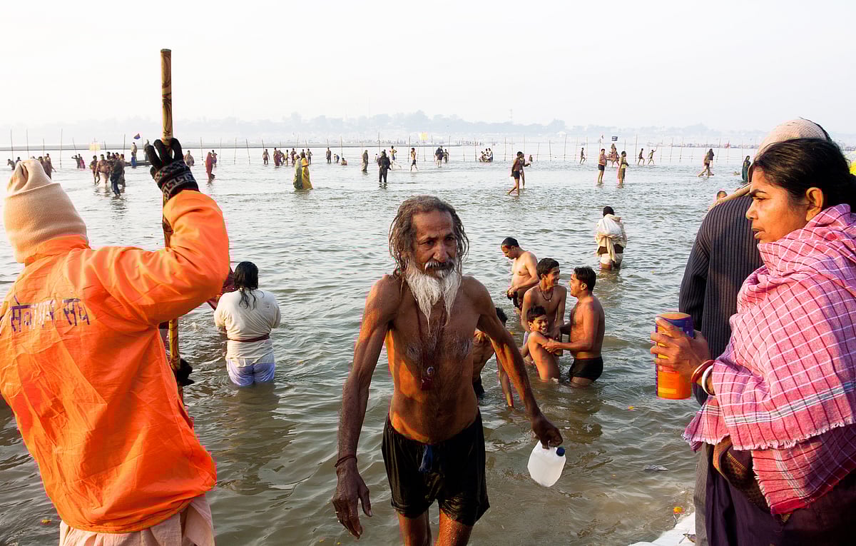 A man takes a dip in the Triveni Sangam during the Paush Purnima