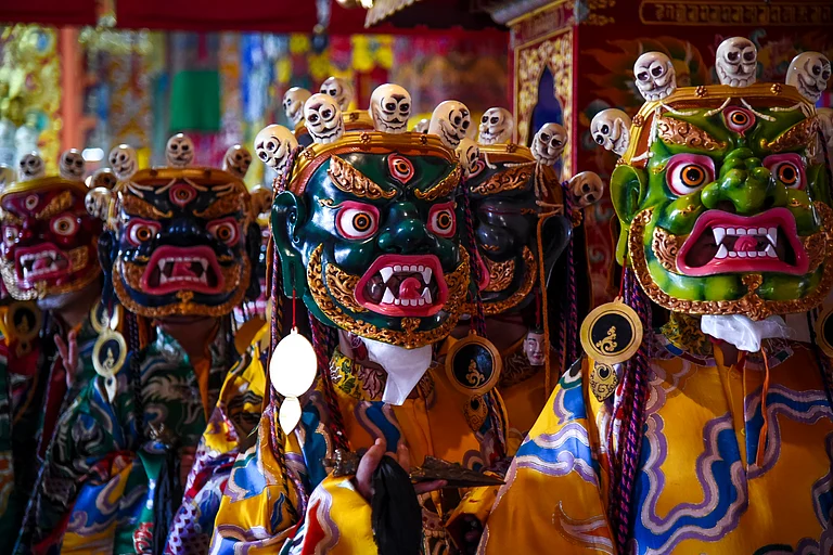 Performers from the Bokar Monastery don masks and get ready to present the Cham Dance - Copyright: Debmalya Das