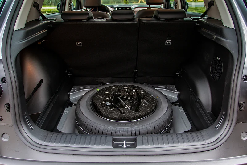 A spare wheel in the trunk of a car