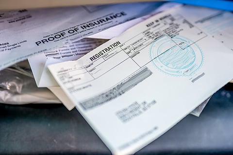 Insurance and vehicle registration papers in the glove box of a car