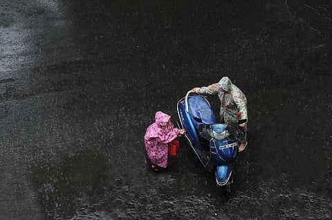 People wearing raincoats in Mumbai