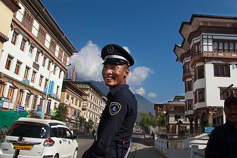 In the streets of Thimphu, a Bhutanese police officer controls traffic with a calm yet authoritative presence