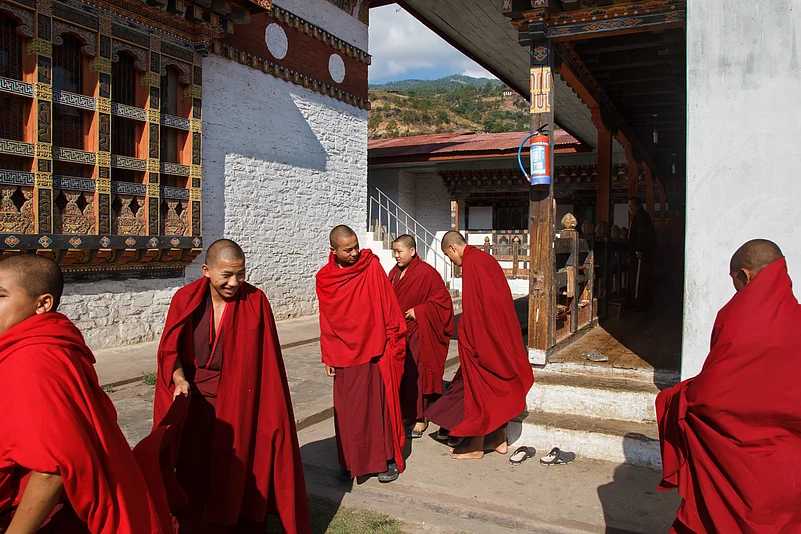 Inside the peaceful Gangtey Monastery, a group of young monks, dressed in their traditional orange-red robes are seen after their study time