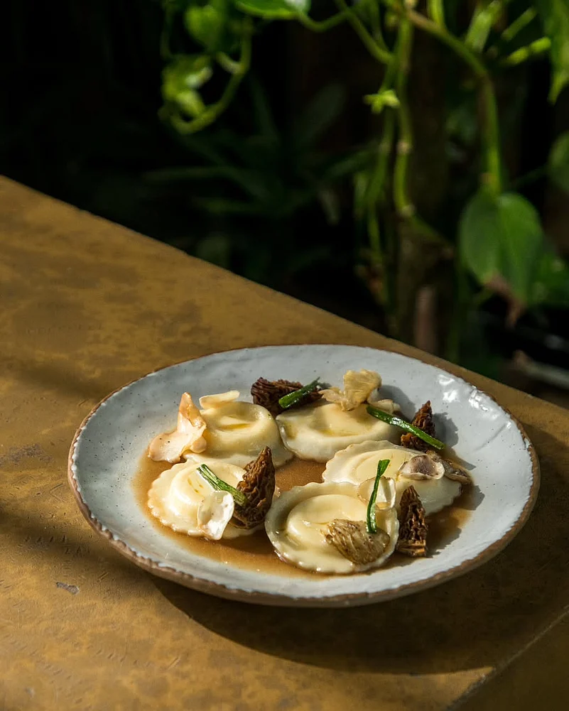 Chef Bhatia promotes using regional and hyperlocal ingredients. Featured here is parmesan ravioli, morel and pink oyster mushrooms, coffee mushroom broth