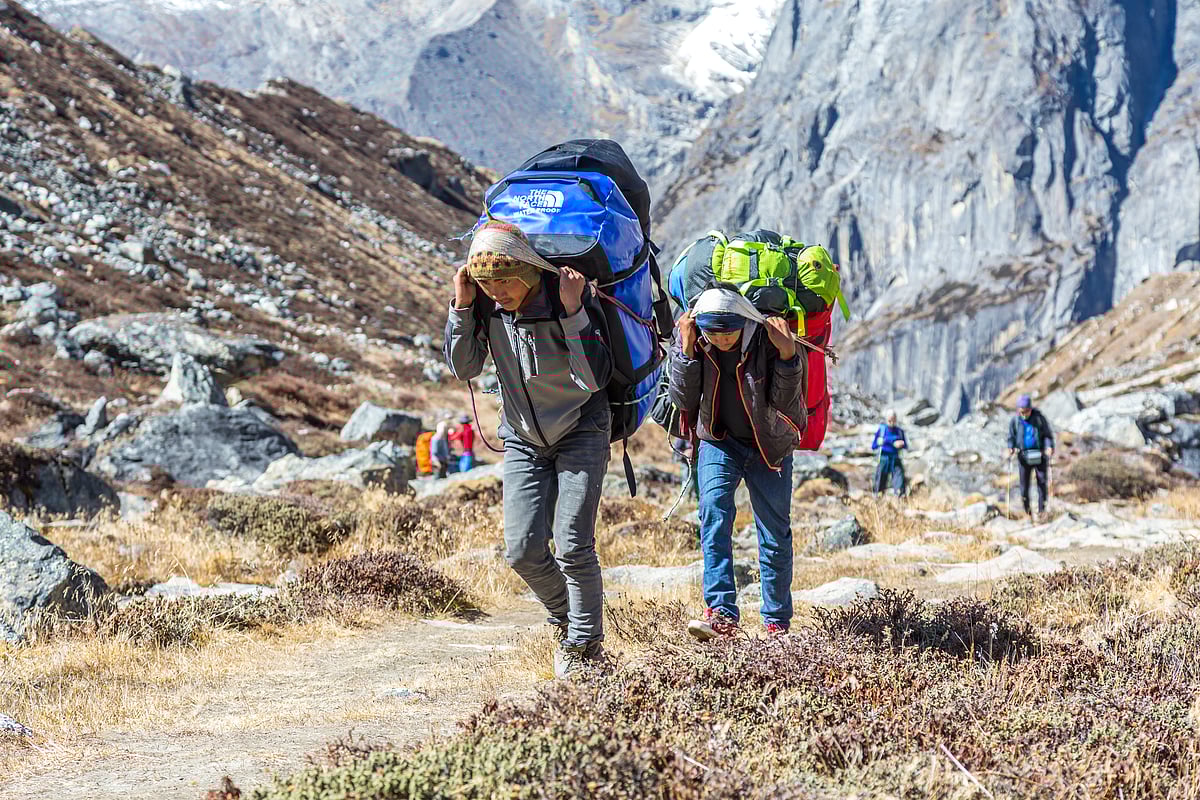 Porters carry gear and baggage on a trek to Meru Peak in the Garhwal Himalayas. This is a representative photo