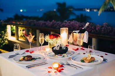 9MOT/Shutterstock : A candlelit dinner table with food and champagne