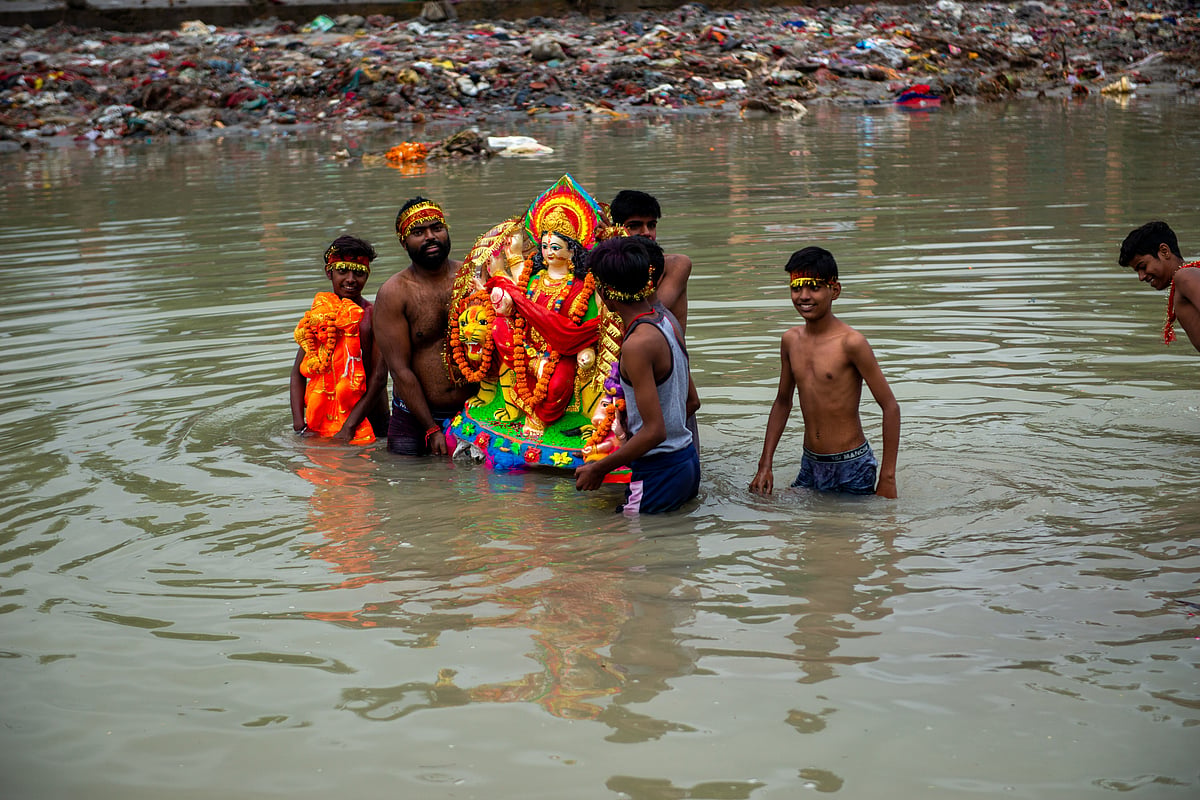 Devotees immerse a Goddess Durga idol in the Upper Ganges canal of Muradnagar