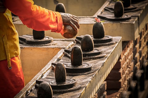 A Hindu priest offers water to Shiva lingams in a temple. (representational photo)