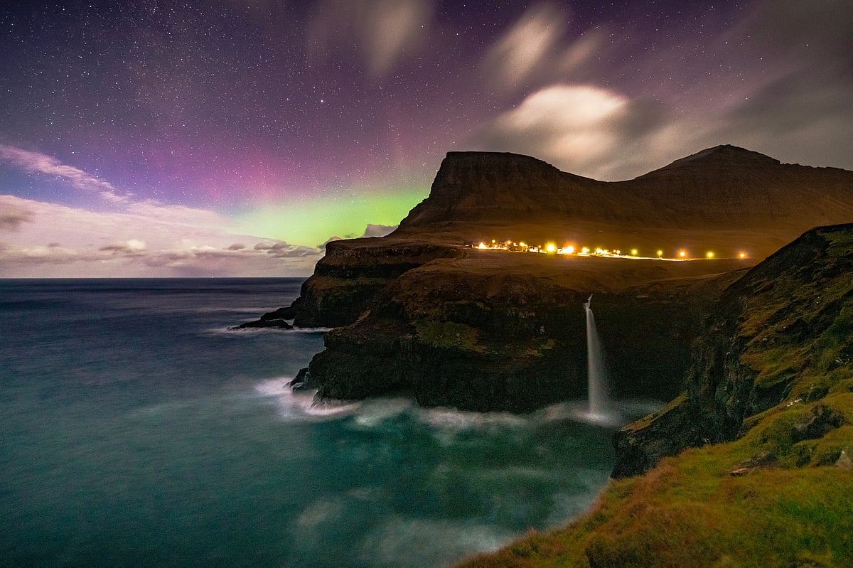 The aurora borealis over the Múlafossur Waterfall in the Faroe Islands.