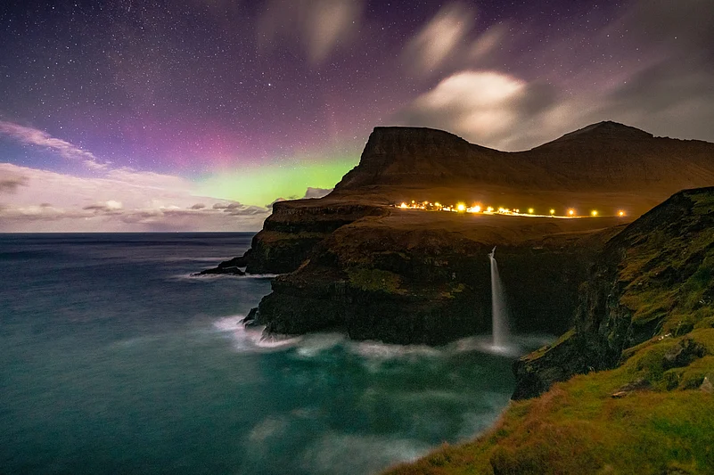 The aurora borealis over the Múlafossur Waterfall in the Faroe Islands.