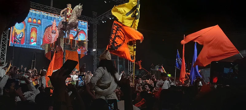 People dance and sing as a person dressed as Shivaji Maharaj enters on a horse.