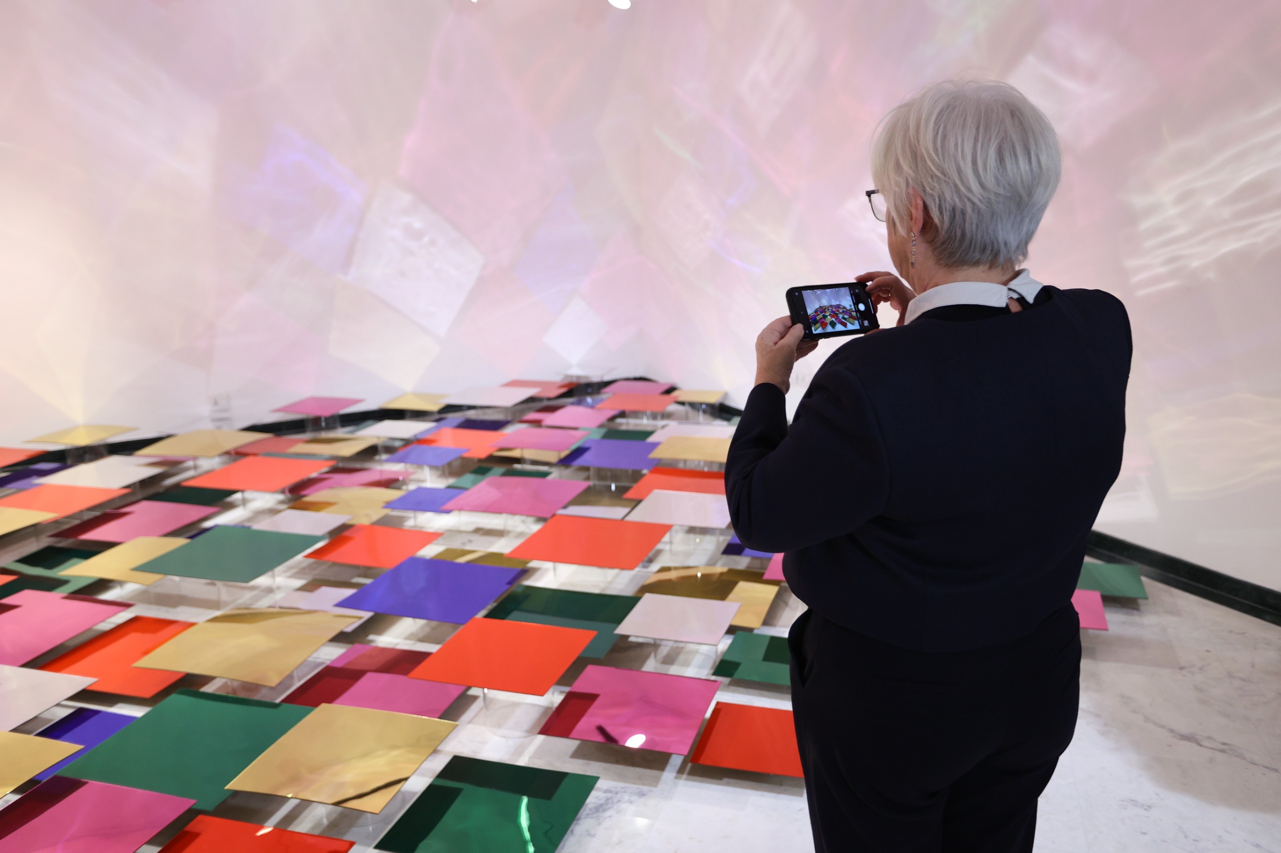 A person photographs Tiered Reflections