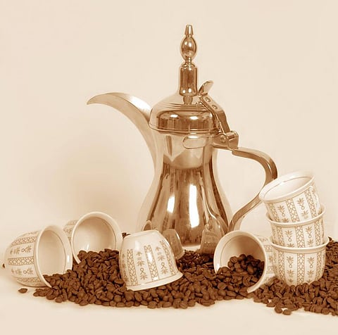 A dallah a traditional Arab coffee pot with cups and coffee beans