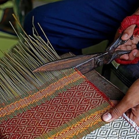 A craftsman at work on a mat