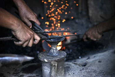 davidtalukdar/Shutterstock : An artisan in Sarthebari crafts a bell metal item