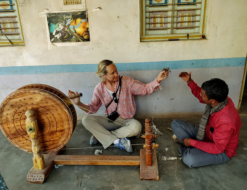 A guest learning how to spin kora cotton thread