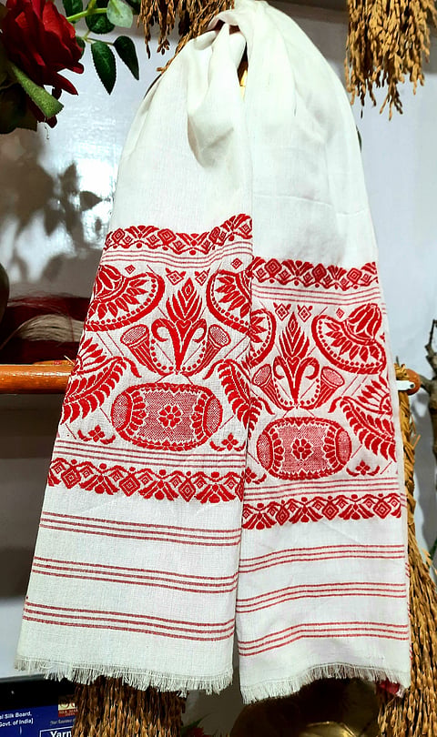 The traditional Gamusa of Assam is worn as a symbol of cultural pride. 