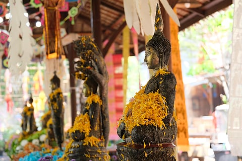 During Songkran, people visit local temples and pour water on Buddha statues, signifying purification and the washing away of one's sins