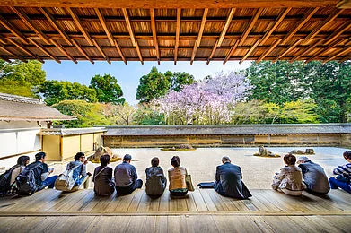 Shutterstock : People sit around the kare-sansui (dry landscape) zen garden at Ryōan-ji