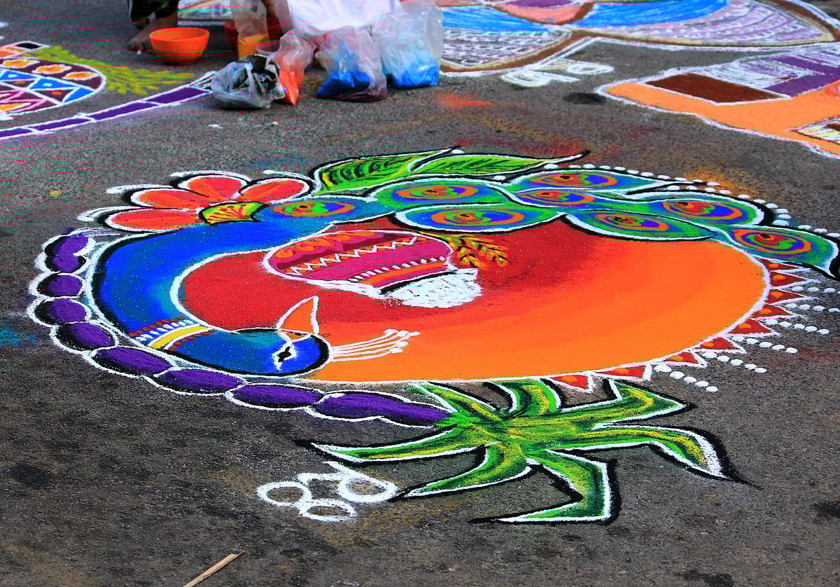 Colourful and intricate floor art called kolam is created using rice powder in front of houses during Puthandu