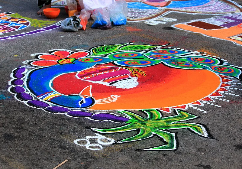 Colourful and intricate floor art called kolam is created using rice powder in front of houses during Puthandu