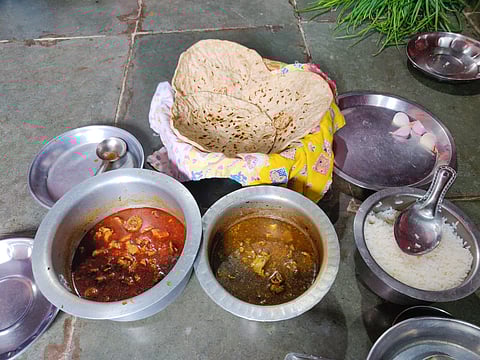 Food prepared by Gunabai Patole, mother of Shahu Patole, at her village home in Osmanabad includes mutton cooked with all its body parts in two styles—Alani, a mildly spiced curry, and a spicy version—served with jowar bhakri, rice, and raw spring onions