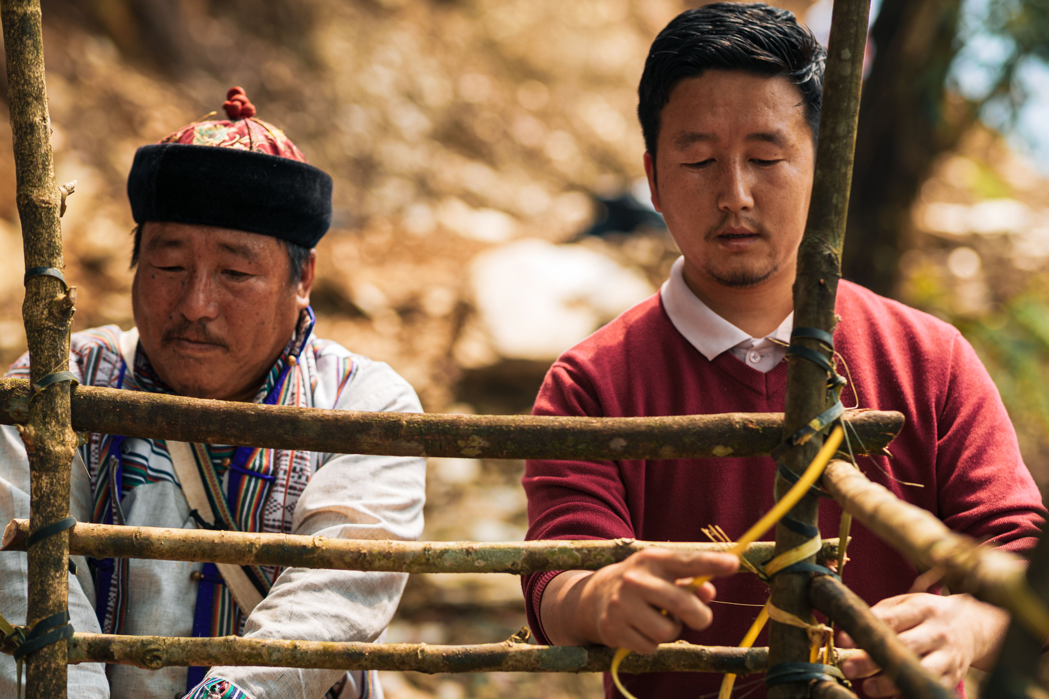 The Bongthing (left), constructing a makeshift elevated platform using local tree stems and bamboo