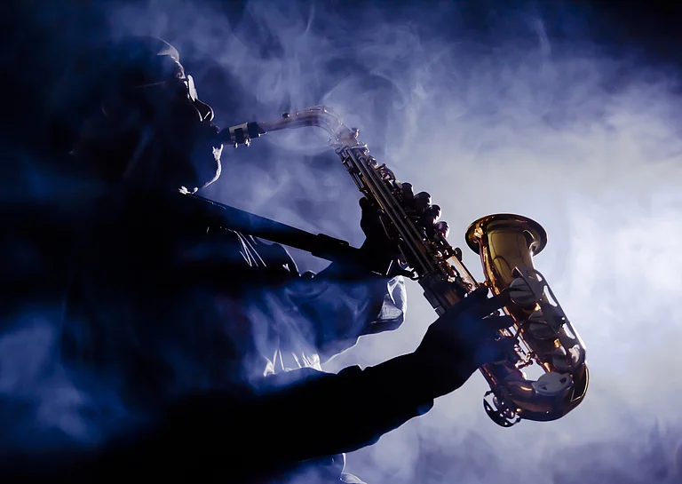A jazz musician in the act in a smoky jazz bar - Shutterstock