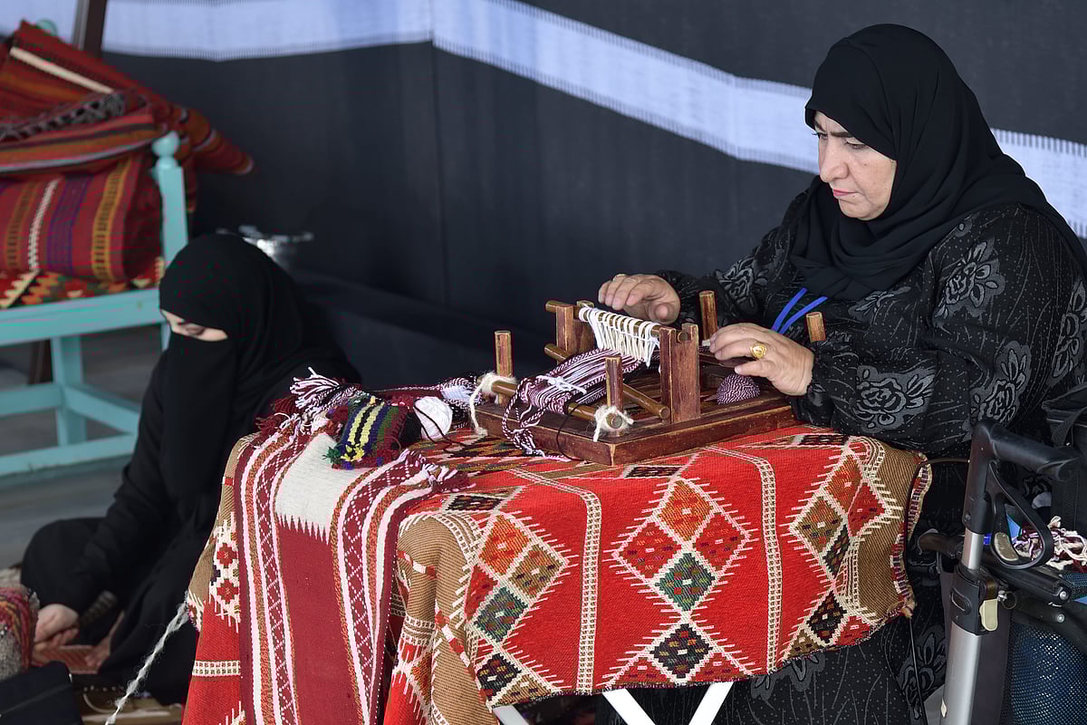 A weaver creates a traditional sadu rug, which is known for its geometric patterns and vibrant colours