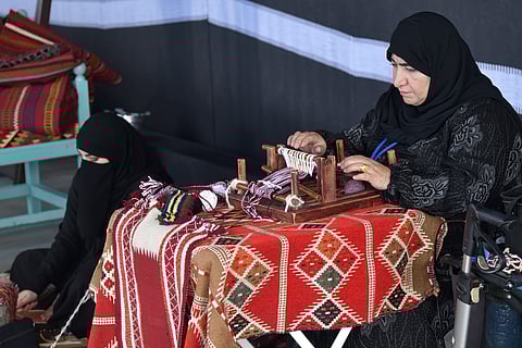 A weaver creates a traditional sadu rug, which is known for its geometric patterns and vibrant colours