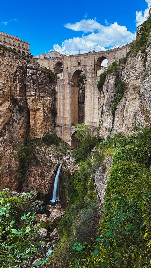 View of bridge in Ronda Spain with waterfall below