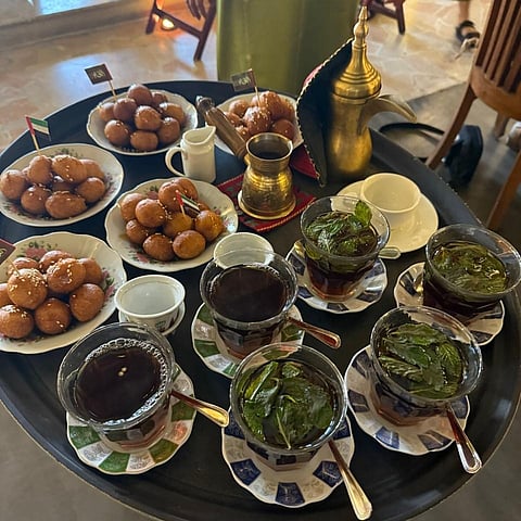 A platter comprising  Luqaimat (Arabic doughnut balls) and herbal tea 