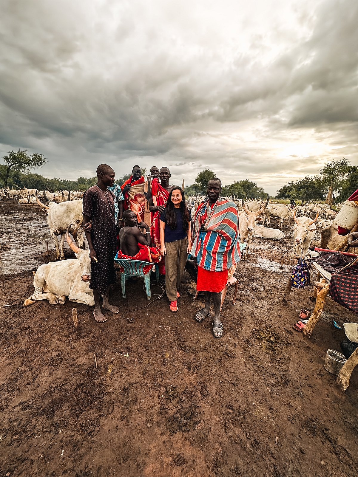 The author believes that travelling allows them to connect with people of different cultures (pictured here: author with the locals of South Sudan)