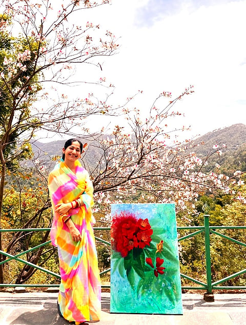 Yashodhara Raje Bundela poses with one of her paintings