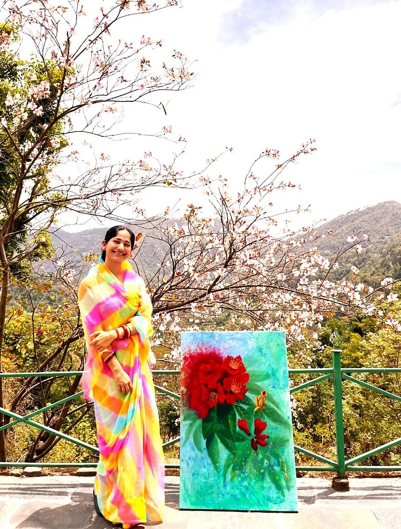 Yashodhara Raje Bundela poses with one of her paintings
