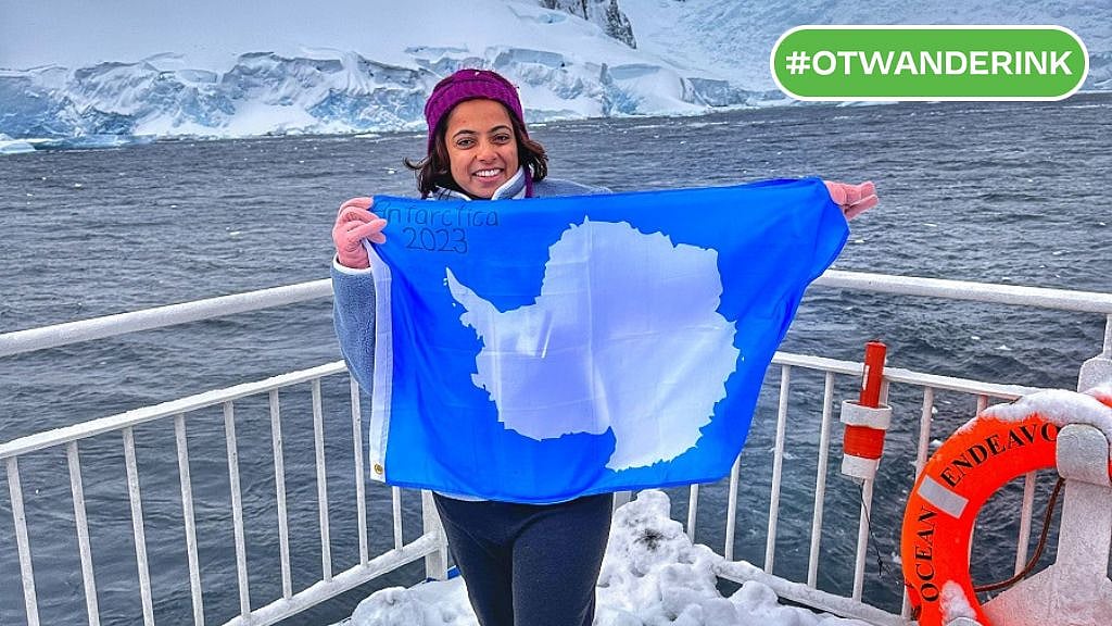 Courtesy of Raksha Nagaraj : The author holding the flag of Antarctica after a successful voyage to the White Continent 