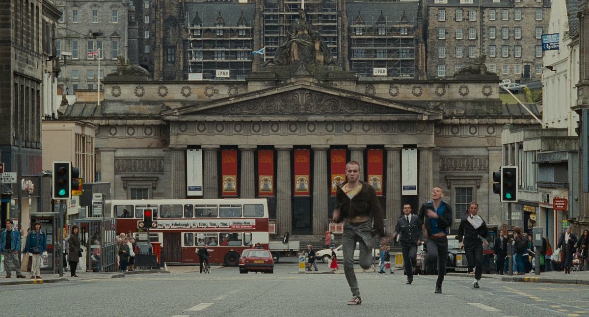 Renton and Spud sprinting down Princes Street in Trainspotting (1996)