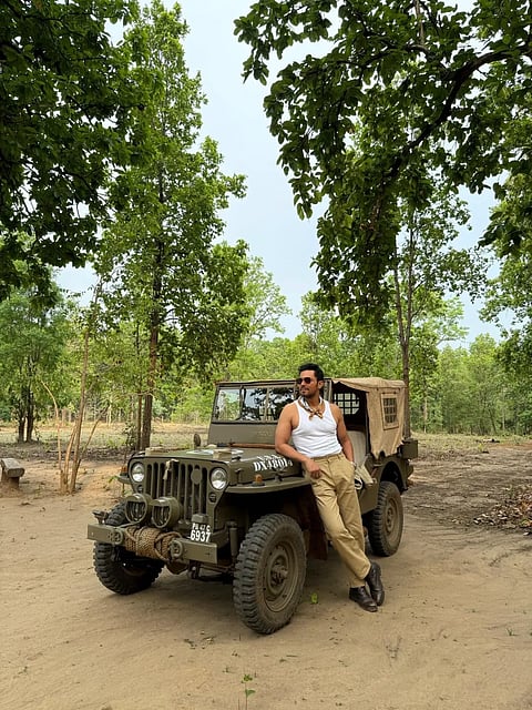 Hood poses by a safari jeep in Kanha