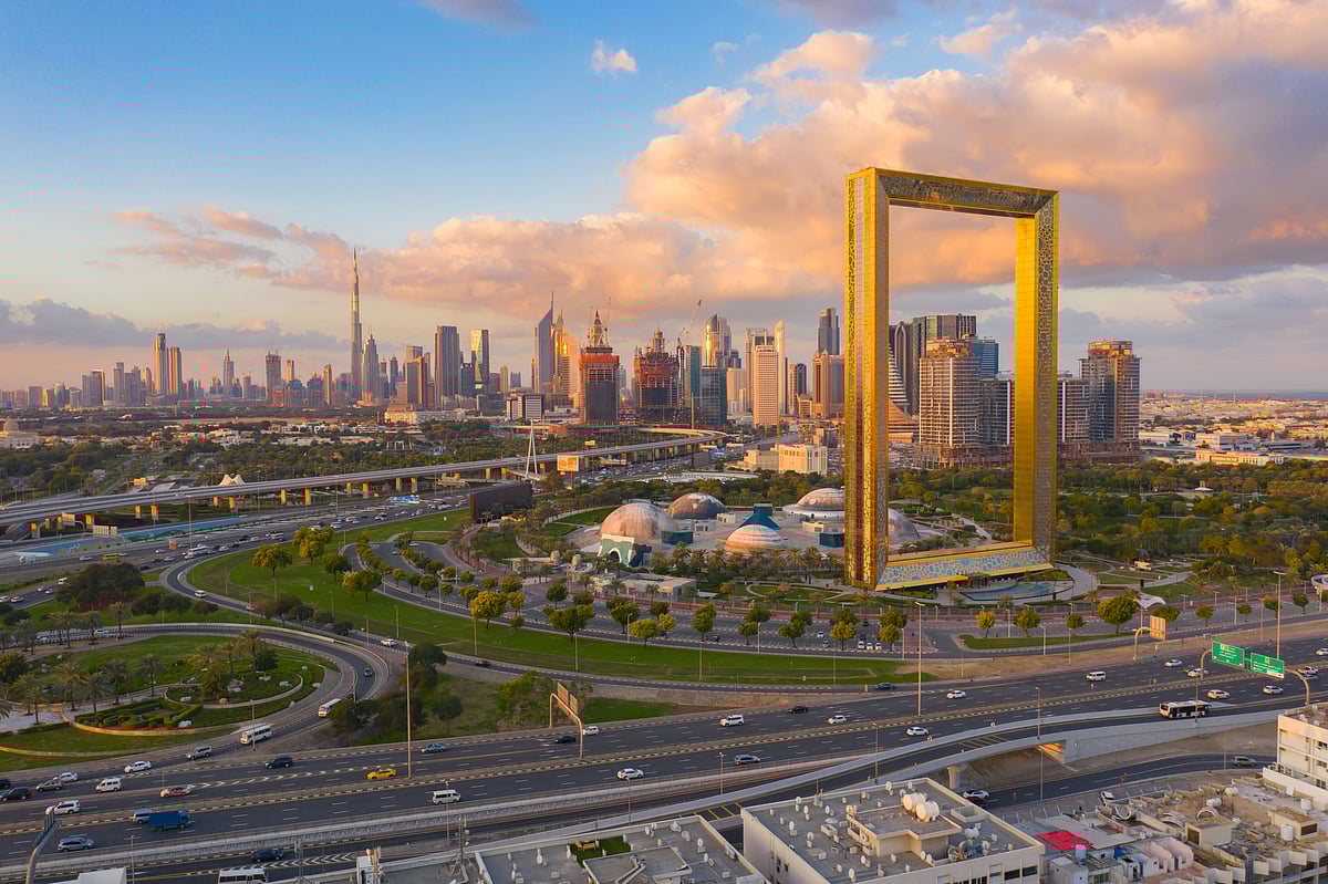A view of the skyline of Dubai with the Dubai Frame in the foreground on the right