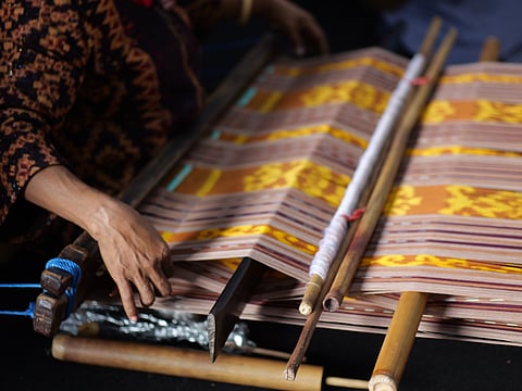A weaver works on Ikat