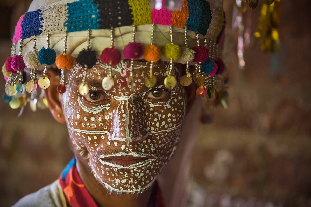 Tribal youth, their bodies adorned with intricate white-dot paint, dance in celebration of age-old Bhil traditions.